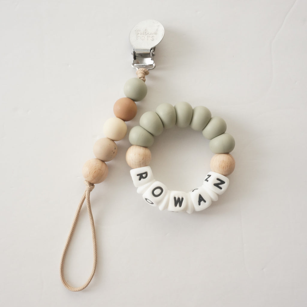 Teething ring with colorful beads and letter beads on a white background